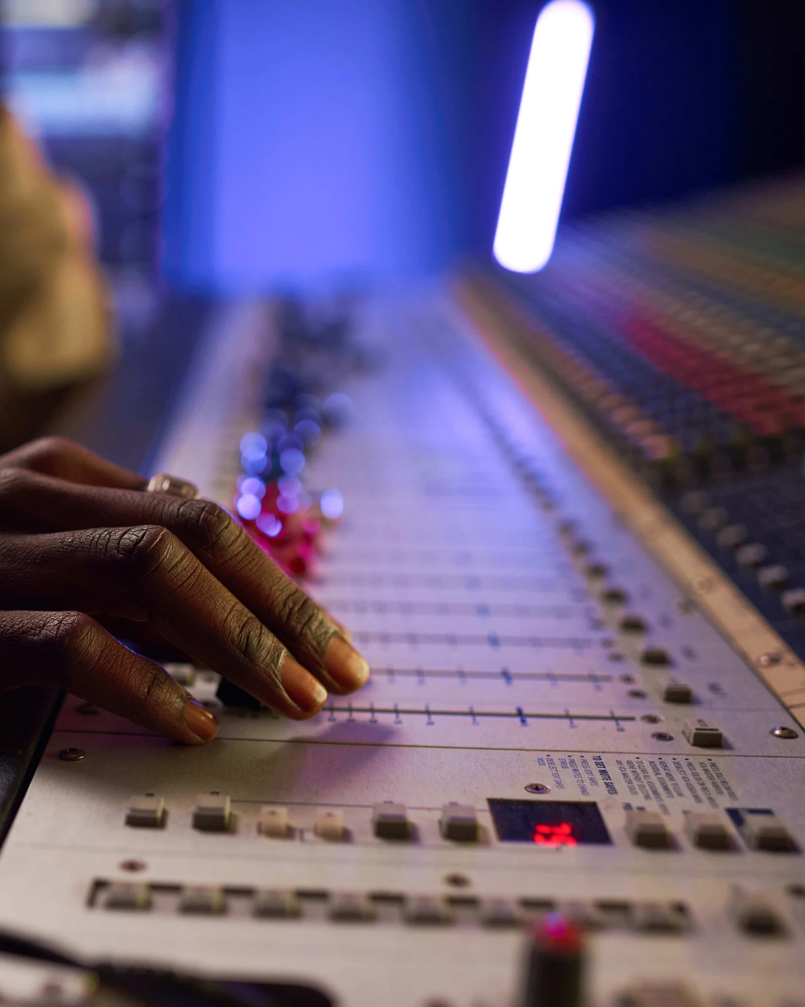 Main d’un ingénieur du son sur la console de mixage du studio