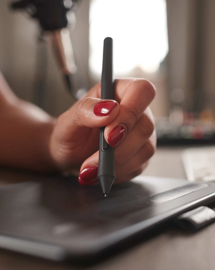 Main dessinant avec un stylet sur une tablette graphique