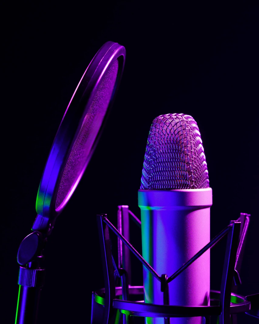 Microphone de studio avec filtre anti-pop sous un éclairage néon violet