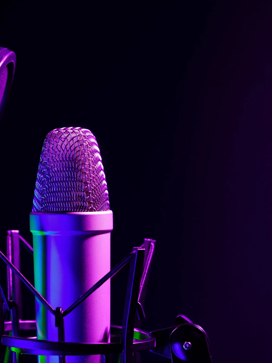 Microphone de studio violet dans sa suspension, sur fond noir